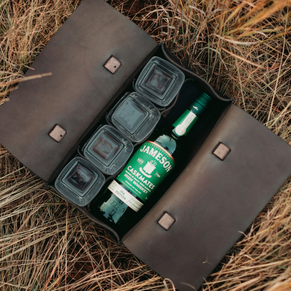 Dark brown leather whiskey bag with jameson whiskey